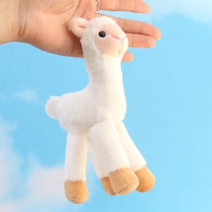 Detailed view of white alpaca plush keychain with metallic clasp and brown feet accents