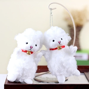 Close-up of white plush sheep charms with fluffy texture and small golden bells