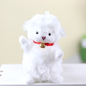 Close-up of fluffy white lamb plush charm with a red ribbon and gold bell detail