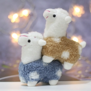 Close-up of blue and brown alpaca plush pendants with soft curly fur and metal chains