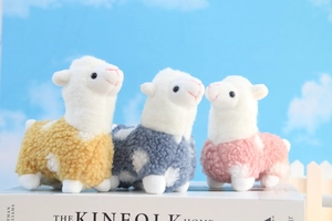 Detailed view of colorful alpaca plush keychains in yellow, blue and pink soft fleece
