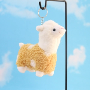 Cute plush alpaca keychain with fluffy brown curly fur and silver ring on a display stand