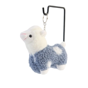 Blue alpaca plush keychain toy with white spots on a metal display stand