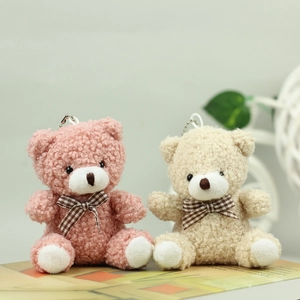 Detail of pink and white plush teddy bears with plaid bows and bead chain hooks