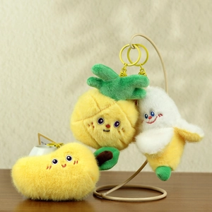 Close-up of plush fruit keychains with cute smiles and yellow metallic hardware