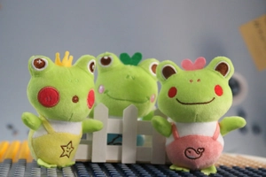 Detailed view of three cute plush frog keychains with crown and heart accessories