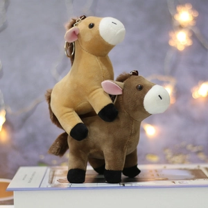 Cute brown plush horse keychains in light and dark shades on books with bokeh lights