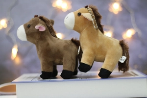 Close-up of brown plush horse keychains with paw print tags and metallic rings
