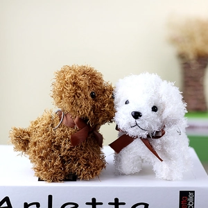 Detail of plush brown and white teddy dog keychains with soft curly fur and brown bows