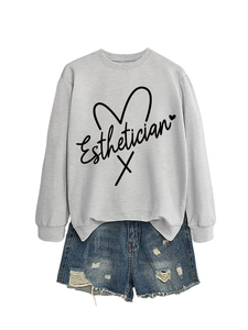 Flat lay of light grey Esthetician sweatshirt paired with distressed denim shorts