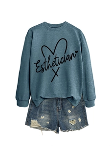 Flat lay of blue-grey Esthetician sweatshirt paired with ripped denim shorts