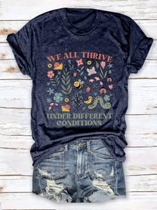 Flat lay of navy blue graphic tee with insect print and frayed denim shorts on wood