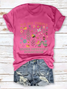 Detail of rose pink cotton T-shirt featuring nature print and denim shorts on wood floor
