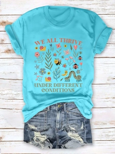 Flat lay of blue T-shirt with nature print and distressed denim shorts on white wood