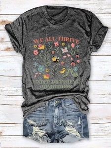 Detailed flat lay of a grey slogan T-shirt with vintage denim shorts on wooden floor