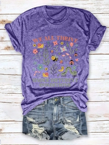 Detailed flat lay of purple heather tee with insect illustration and slogan on wood background