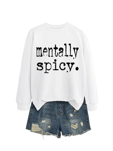 Mise à plat d'un sweat-shirt blanc Mentally Spicy et d'un short en jean bleu délavé troué