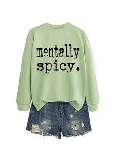Mise à plat du sweat vert clair avec imprimé Mentally Spicy et short en jean déchiré