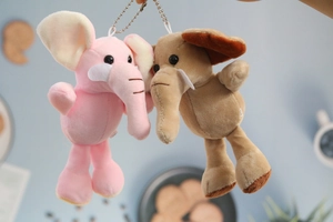 Gros plan de porte-clés éléphants en peluche rose et marron avec chaînes argentées