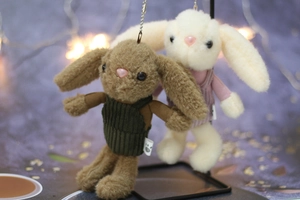 Detail of plush bunny keychains in velvet overalls with cute metal ball chains