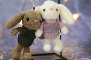 Close-up of cute plush bunny keychains with corduroy outfits and metal bead chains