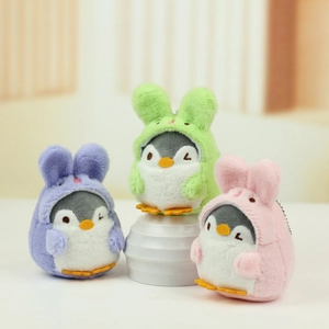 Three cute plush penguin keychains in colorful bunny hoodies on a display stand