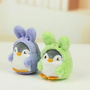 Close-up of purple and green penguin plush pendants wearing bunny hoods with soft texture