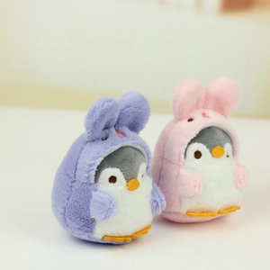 Close-up of cute plush penguin pendants with rabbit ears in soft purple and pink colors