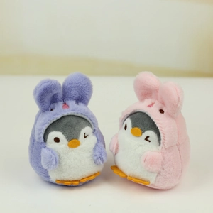 Detail of plush penguin charms wearing pink and purple bunny hoodies with embroidery