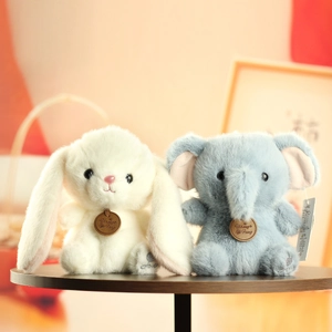 Close-up of soft plush rabbit and elephant toys showing premium fur texture on wood table