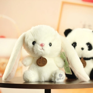 Close-up of white plush bunny featuring a brown leather brand tag and love embroidery