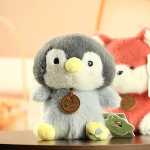 Detailed view of gray penguin plush toy featuring soft fur texture and leather brand tag