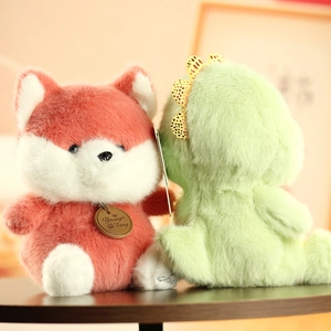 Close-up of red fox and green dinosaur plush toys on a dark wood surface