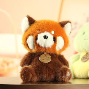 Close-up of red panda plush toy with embroidered paw details and metallic brand tag
