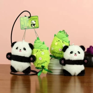 Schattige panda pluche sleutelhanger set met bamboescheuten op houten tafel