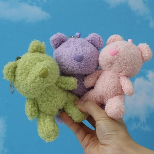 Detailed view of plush teddy bear keychains in green, purple and pink with colorful straps