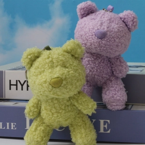 Detail of light green and purple curly plush teddy bear charms with metal keyrings