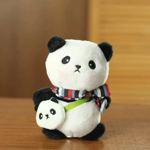 Detail van panda pluche sleutelhanger met sjaal en mini-tas op houten tafelblad