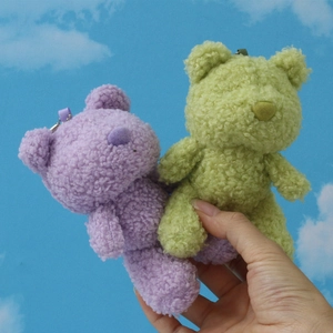 Handheld teddy bear keychain charms in purple and green plush with curly lamb wool texture
