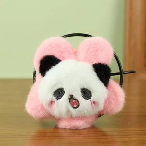 Detail van roze pluchen haaraccessoire met geborduurde pandakop op houten oppervlak