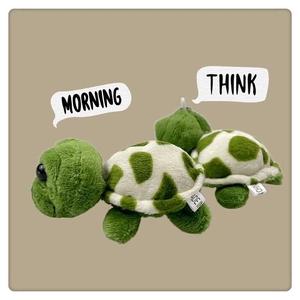 Close-up of cute green turtle plush pendant with soft texture and white belly details