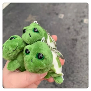 Detailed view of three cute green plush turtle charms with metal keyrings