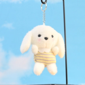 Detail van witte pluche hondenknuffel met geel gestreept shirt voor de blauwe lucht