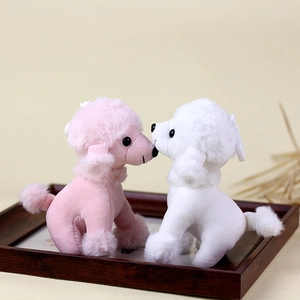 Detail van roze en witte pluchen puppy-sleutelhangers die kussen op een houten dienblad