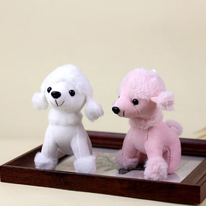 Detailopname van de witte en roze poedel pluche sleutelhangers op houten dienblad