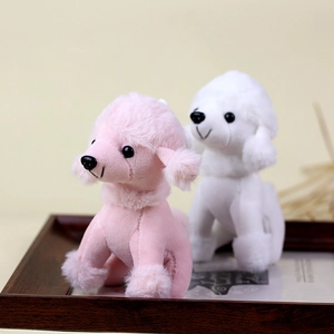 Gedetailleerd beeld van de schattige roze en witte pluche poedel sleutelhangers in houten tray