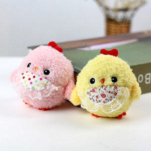 Plush chick keychain pair in pink and yellow with lace bibs on a cozy book background