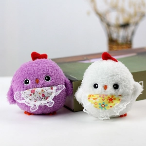 Close-up of cute plush chicks with lace bibs on a cozy background with books