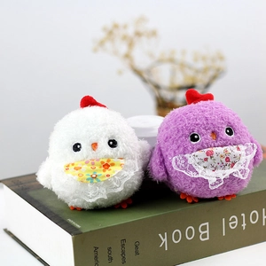 Close-up of cute plush chicks in white and purple with lace bibs on a vintage book
