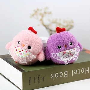 Detail of pink and purple plush chicken toys with lace bibs and red heart headwear